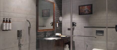 Un baño moderno con ducha envuelta en vidrio, tocador con espejo y retrete.