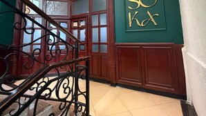 A staircase with ornate metal railings, a wooden door, and a wall with a sign. - Iconic Coworking Hotel (Addis Ababa)
