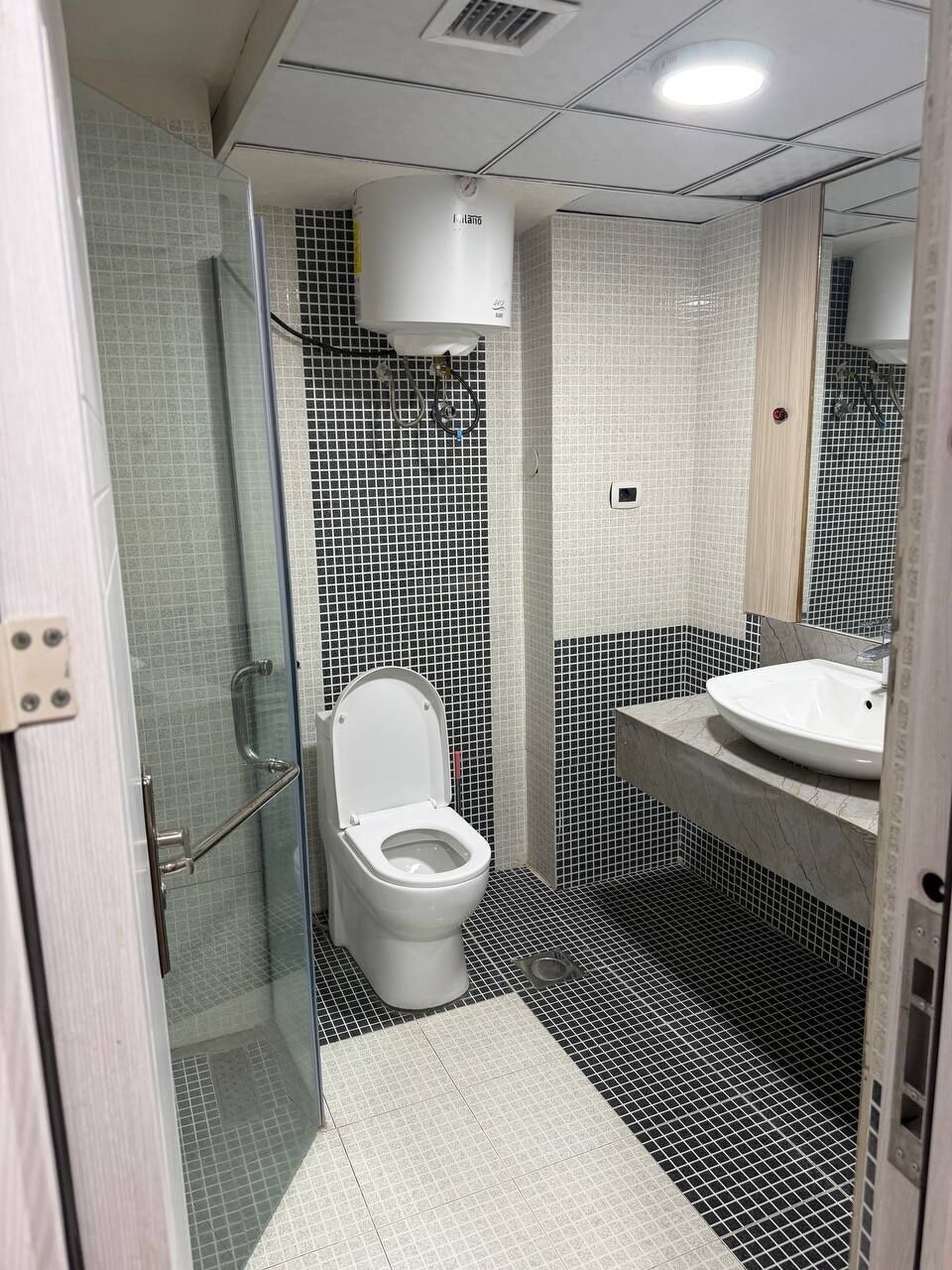Une salle de bain comprenant des toilettes, un lavabo et un espace douche.