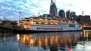 A large riverboat with multiple decks and a prominent building in the background. - Quiet, 3-bedroom house with calm natural light (Nashville)