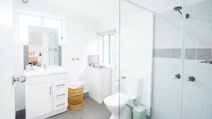 A modern bathroom with a glass shower enclosure, a white sink, and a toilet. - Pink Muse, 3 Mins to Ettalong Beach (Ettalong Beach)