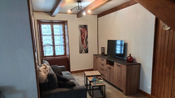 Ein Wohnzimmer mit einer Couch, einem Couchtisch, einem Fernseher und Holzschränken.