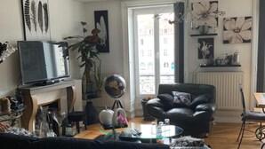 Una sala de estar con sofá, televisor, un globo terráqueo y chimenea.