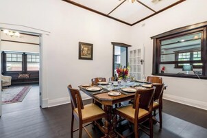 Un comedor con una mesa de madera dispuesta para cuatro personas, rodeado de sillas.