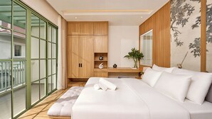 Quarto moderno com uma cama grande, uma escrivaninha e vista para uma varanda.