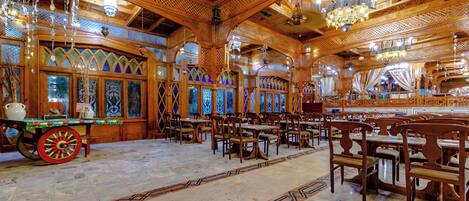 A spacious hall with wooden furniture and intricate ceiling designs.