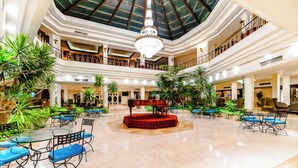 Un vaste atrium agrémenté d’un magnifique lustre, de plusieurs niveaux et d’une végétation luxuriante.