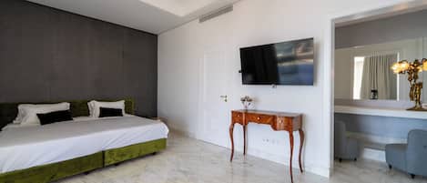 A modern bedroom with a green bed, a flat-screen TV, a wooden side table, and a mirror.
