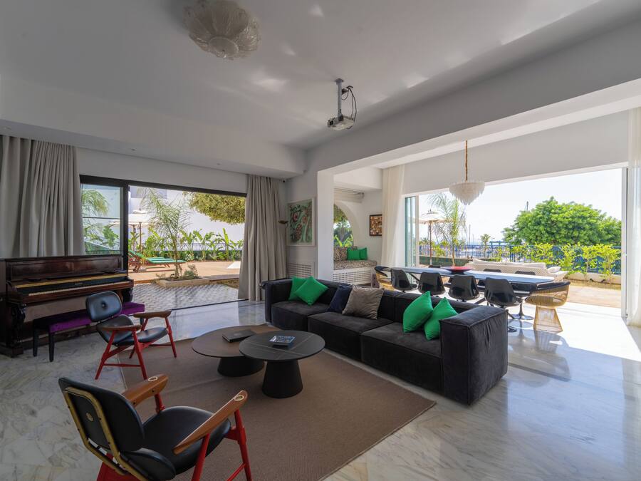 A spacious living area with a piano, sofas, and a dining table.