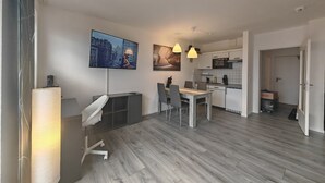 A modern apartment with a dining area, kitchen, and living space. - Guest apartment and service apartment Hermsdorf (Hohe Börde)
