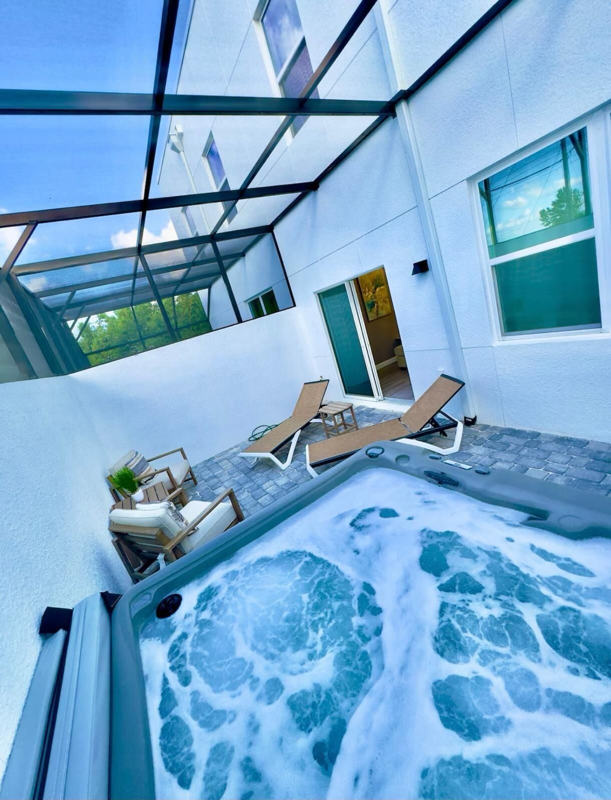 A hot tub area with lounge chairs and a glass ceiling structure.