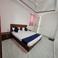 Uma cama bem arrumada com cabeceira de madeira, mesa de cabeceira e criado-mudo.
