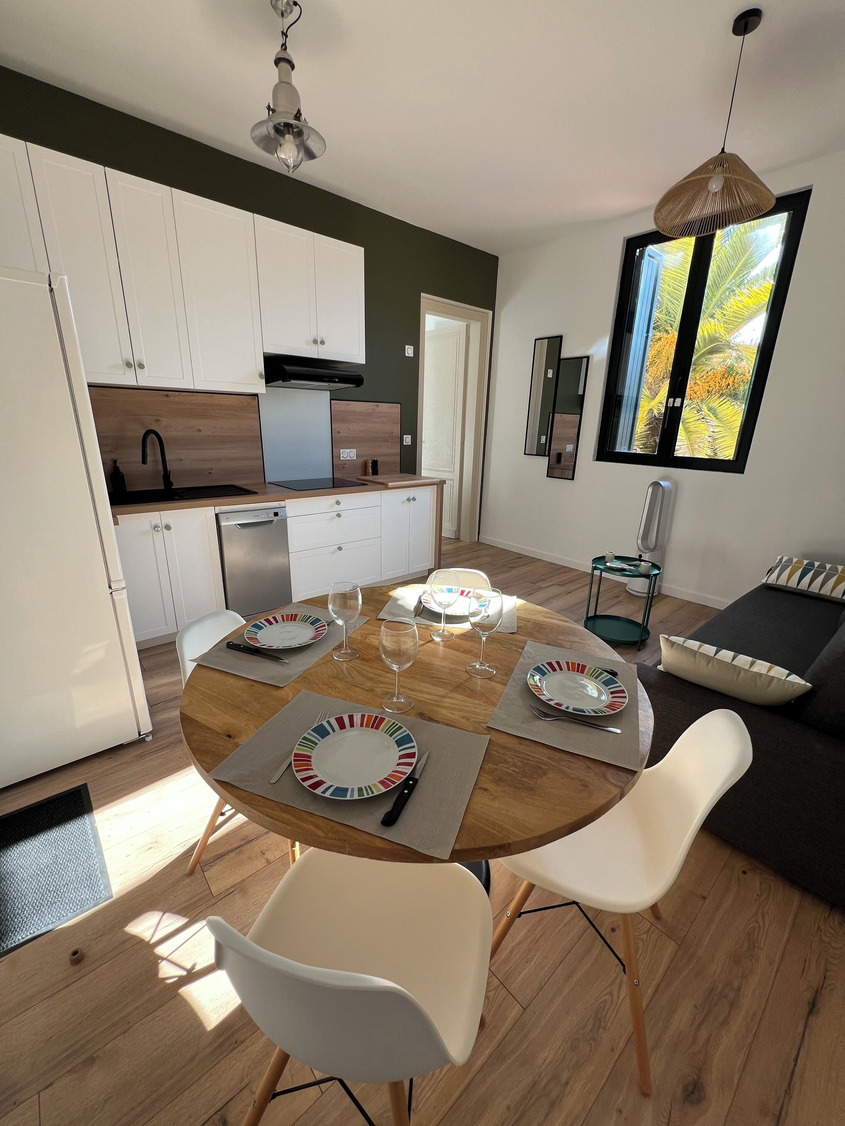 A modern kitchen with white cabinets, a wooden countertop, and a built-in dishwasher.