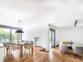 Un espacio habitable amplio con una mesa de comedor, sillas, un sofá y una mesa baja.