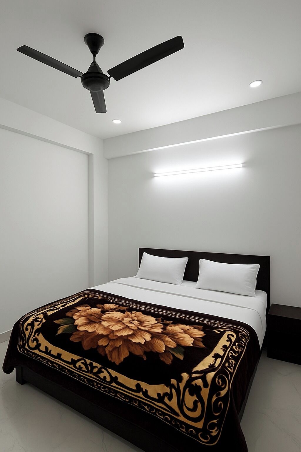 Een moderne slaapkamer met een bed, een plafondventilator, inbouwverlichting en een decoratieve spreidekker.