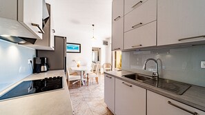 Una cocina moderna con estufa integrada, un lavamanos y armarios.