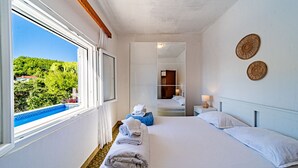 A hotel room with a large window, a bed, a bedside table with a lamp, and a mirror. - Waterfront House Arnet by Villas Guide (Blato)