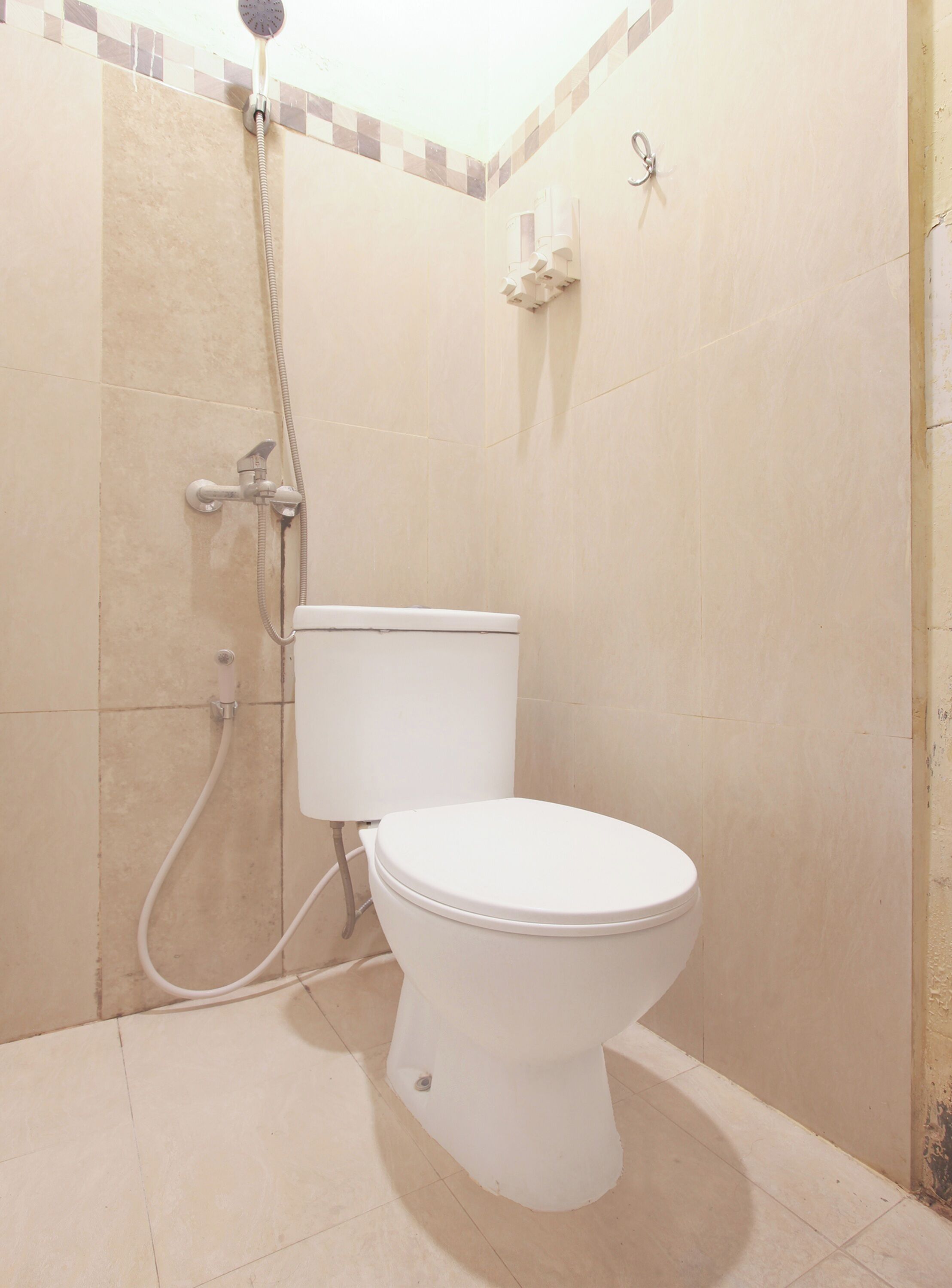 A bathroom with a toilet, a shower, and a towel rack.