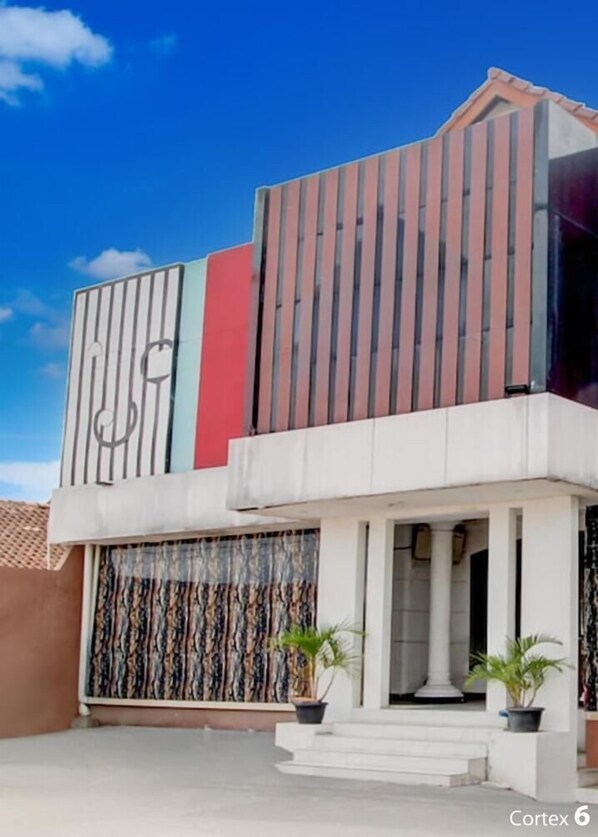 A modern two-story building with a flat roof, large windows, and a balcony. - Hotel O near Maguwoharjo Stadium formerly Graha Ngaso (Depok)