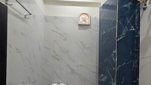 A bathroom with a toilet, shower, and a water heater.