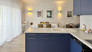 Una cocina moderna con una isla central, electrodomésticos integrados e iluminación empotrada.