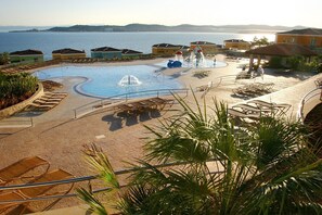 A resort pool area with a water feature, lounge chairs, and a view of the sea. - A two bedroom, sea view apartment in Skiper & Golf Resort Savudrija - Hortenzija (Crveni Vrh)