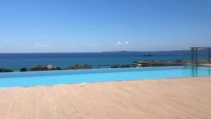 Una piscina con vistas al mar y edificios a lo lejos.