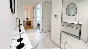 Un baño moderno con un espejo, una mesita de consola y una zona de ducha.