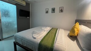 A bedroom with a bed, a window, and three framed botanical prints on the wall. - LimeTree Loft Guesthouse (Patong)