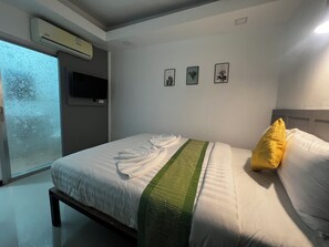 A bedroom with a bed, a window, and three framed botanical prints on the wall. - LimeTree Loft Guesthouse (Patong)