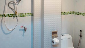 Un baño con ducha, inodoro y un perchero para toallas.