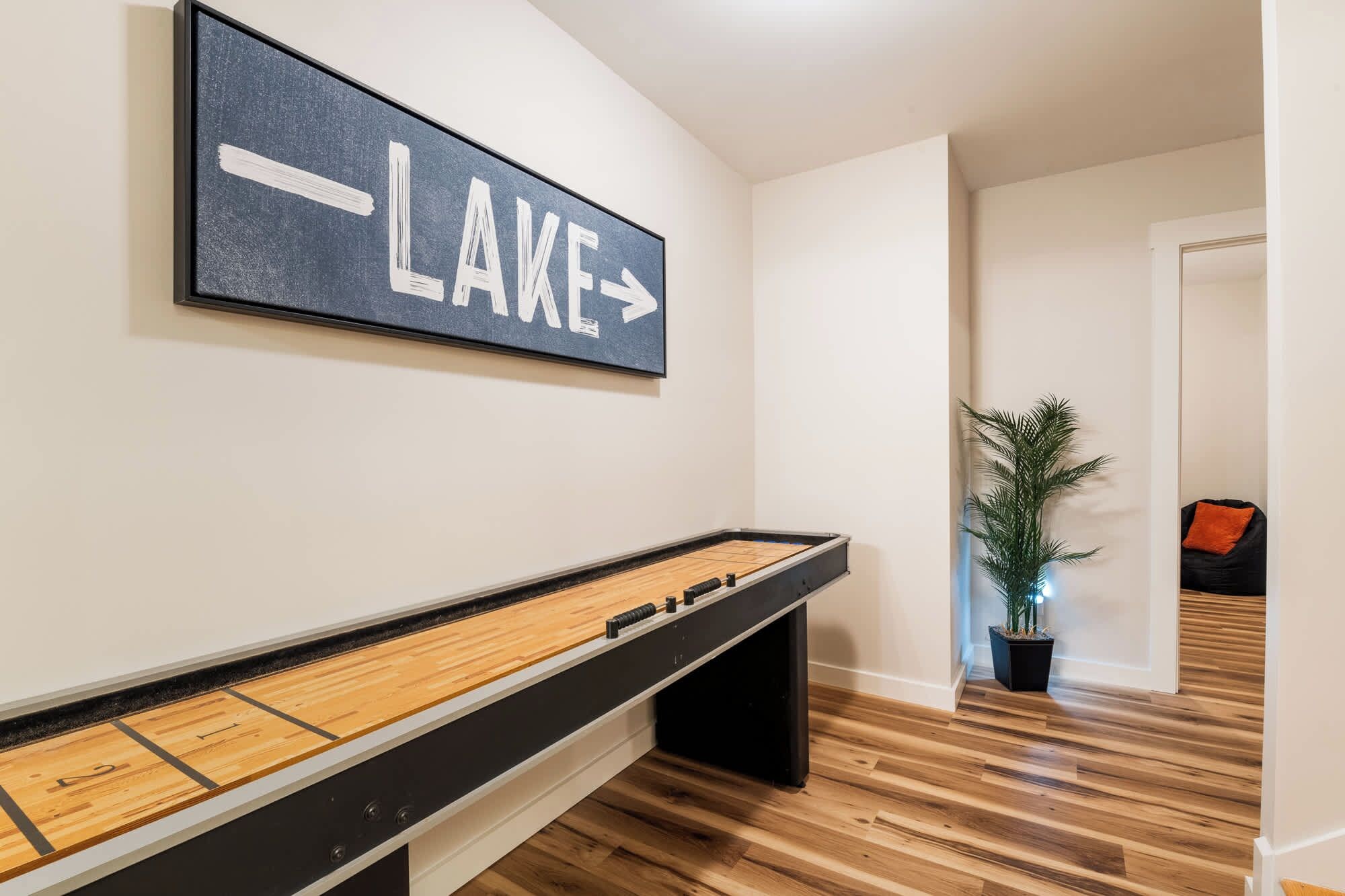 Une table de baby-foot est installée dans un couloir, et une pancarte au-dessus indique le mot « LAKE ».