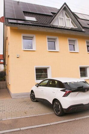 Ein gelbes Gebäude mit einem weißen Auto davor.