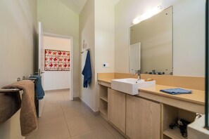 A bathroom with a white sink, a mirror, and a towel rack. - Villa Lagoon by Oazure (Trou d'eau douce)