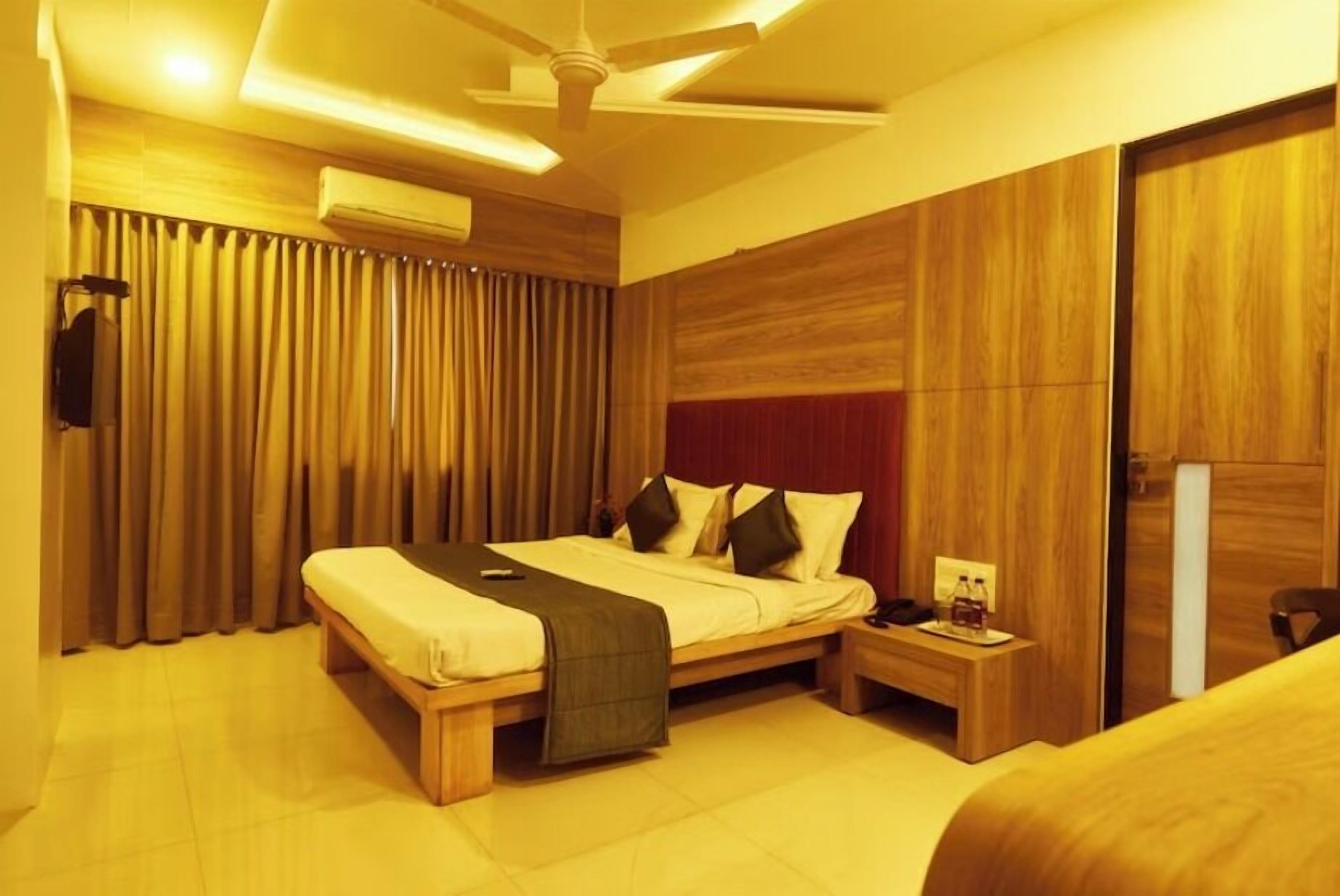 A hotel room with a bed, bedside table, and a ceiling fan.