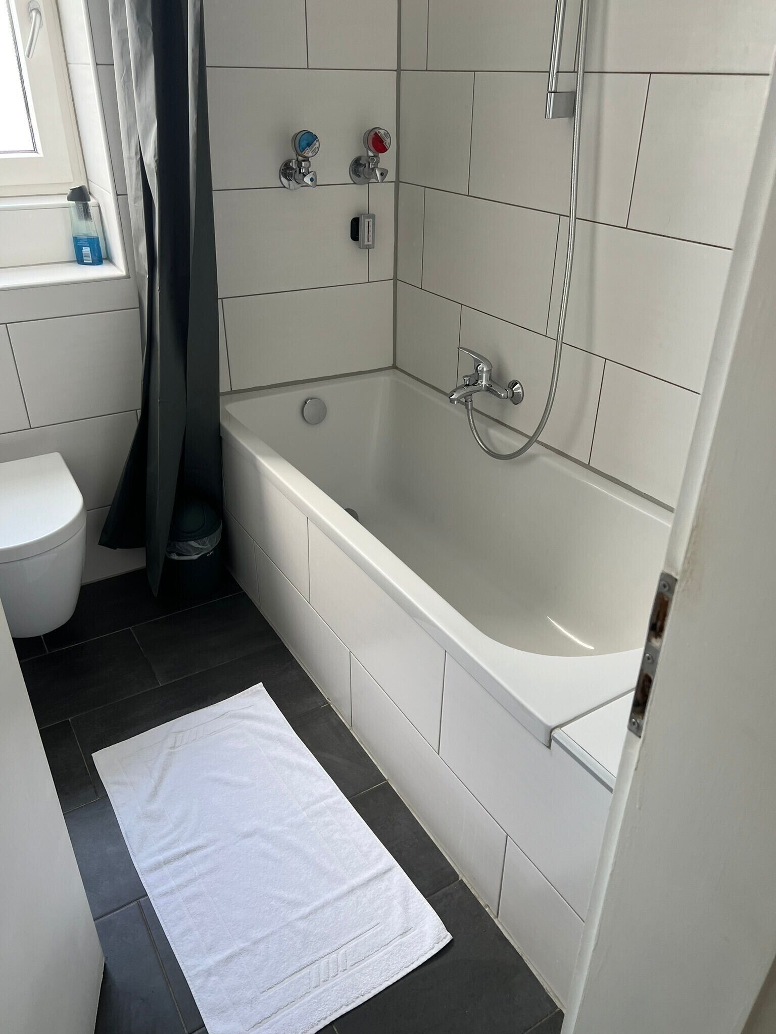 A bathroom with a bathtub, toilet, and shower.