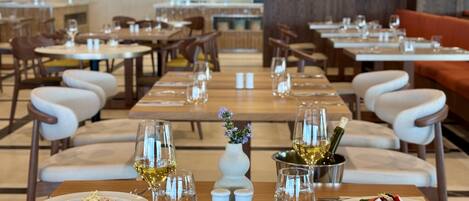 A restaurant with multiple tables, each set with plates, glasses, and cutlery.