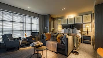 Ein modernes Hotelzimmer mit Bett, Sitzgelegenheit und Bildern an der Wand.