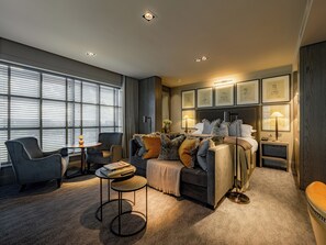 A modern hotel room with a bed, seating area, and artwork on the walls. - Dakota Manchester Airport (Manchester)