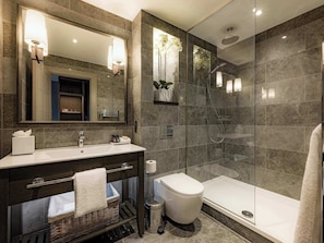 A modern bathroom with a glass-enclosed shower, a large mirror, and a dark-toned vanity. - Dakota Manchester Airport (Manchester)
