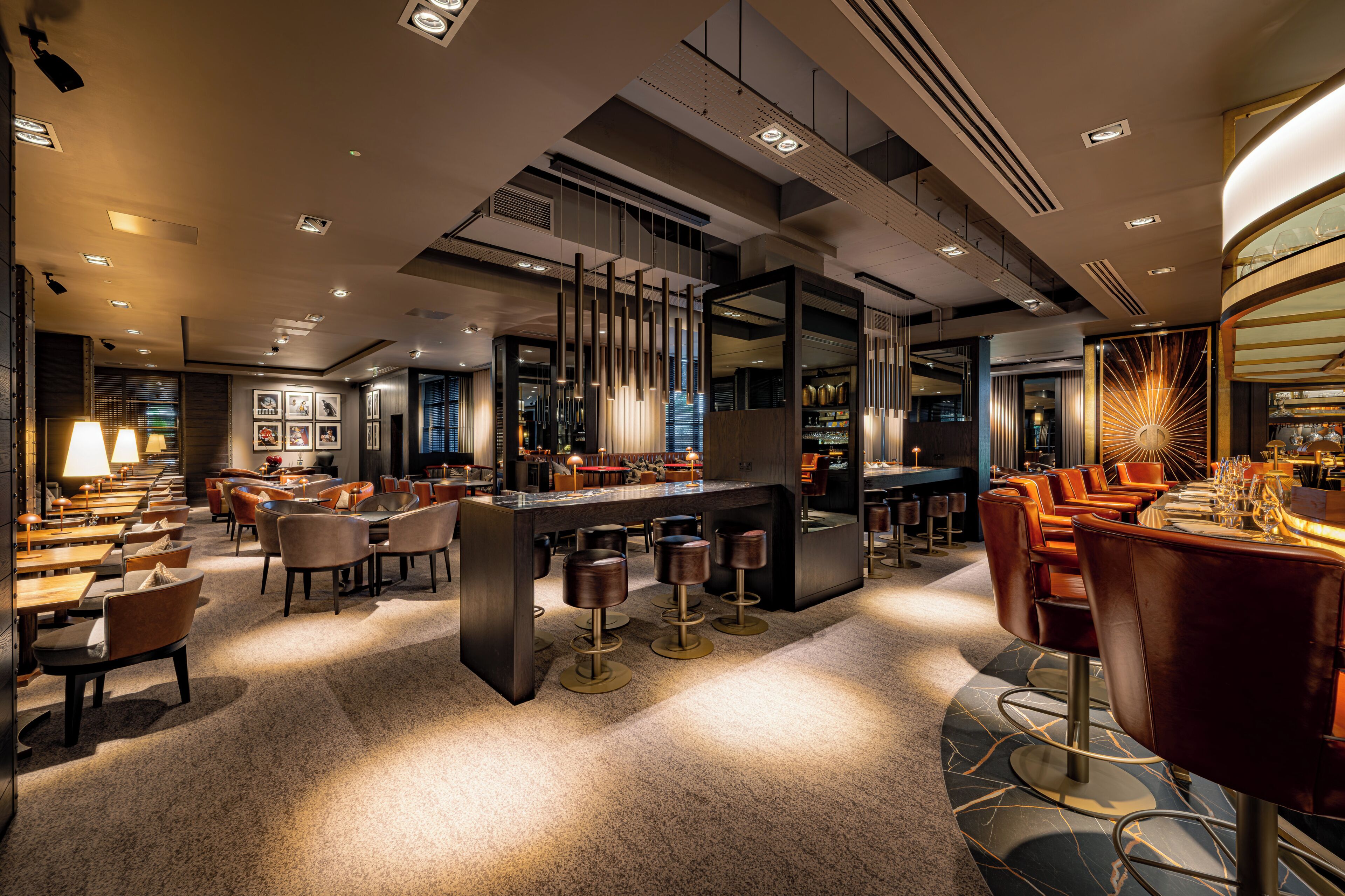 A modern hotel lobby with a bar area, seating arrangements, and a central island.