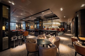 Zona bar moderna con posti a sedere e bancone.
