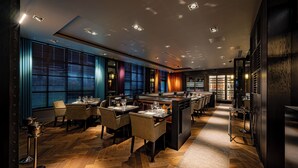 A modern restaurant interior with wooden flooring, tables set for dining, and a bar area. - Dakota Manchester Airport (Manchester)
