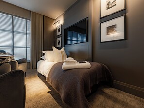 Una camera d'albergo moderna con un letto grande, una scrivania e vista sulla città dalla finestra.