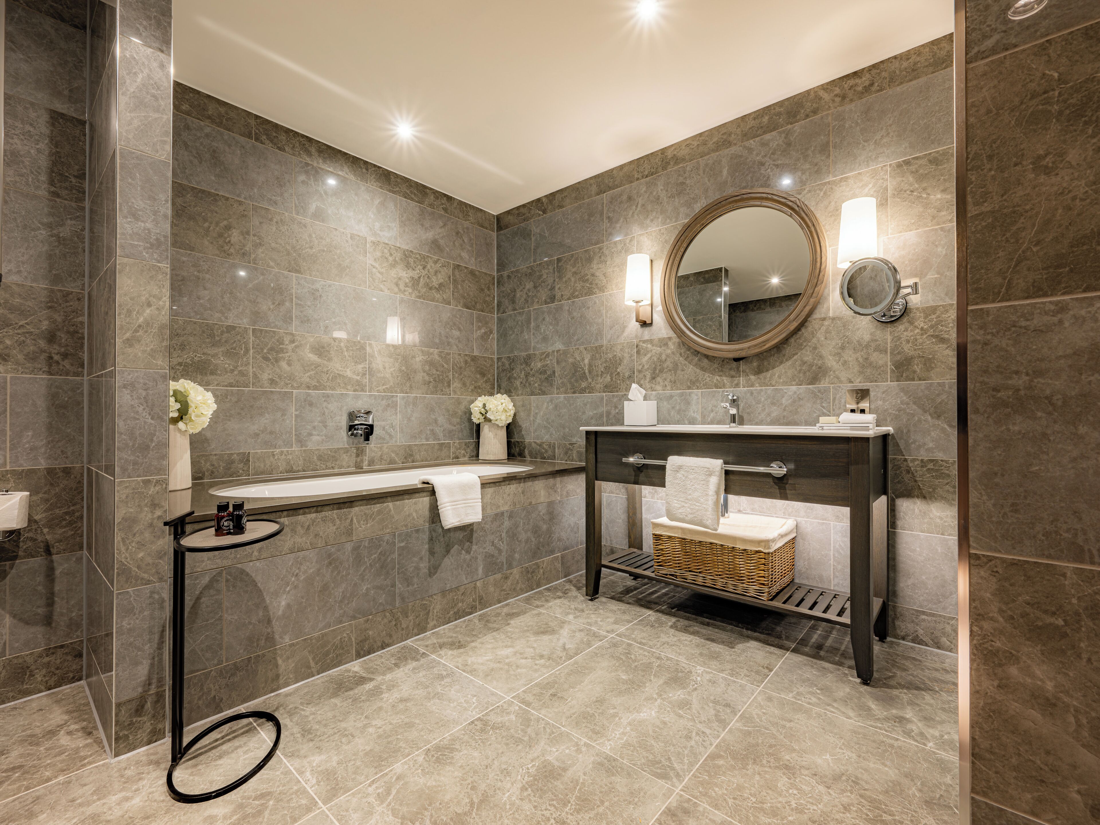 Ein modernes Badezimmer mit einer Badewanne, einem Waschtisch mit Spiegel und einer Toilette.