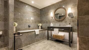 Ein modernes Badezimmer mit einer Badewanne, einem Waschtisch mit Spiegel und einer Toilette.