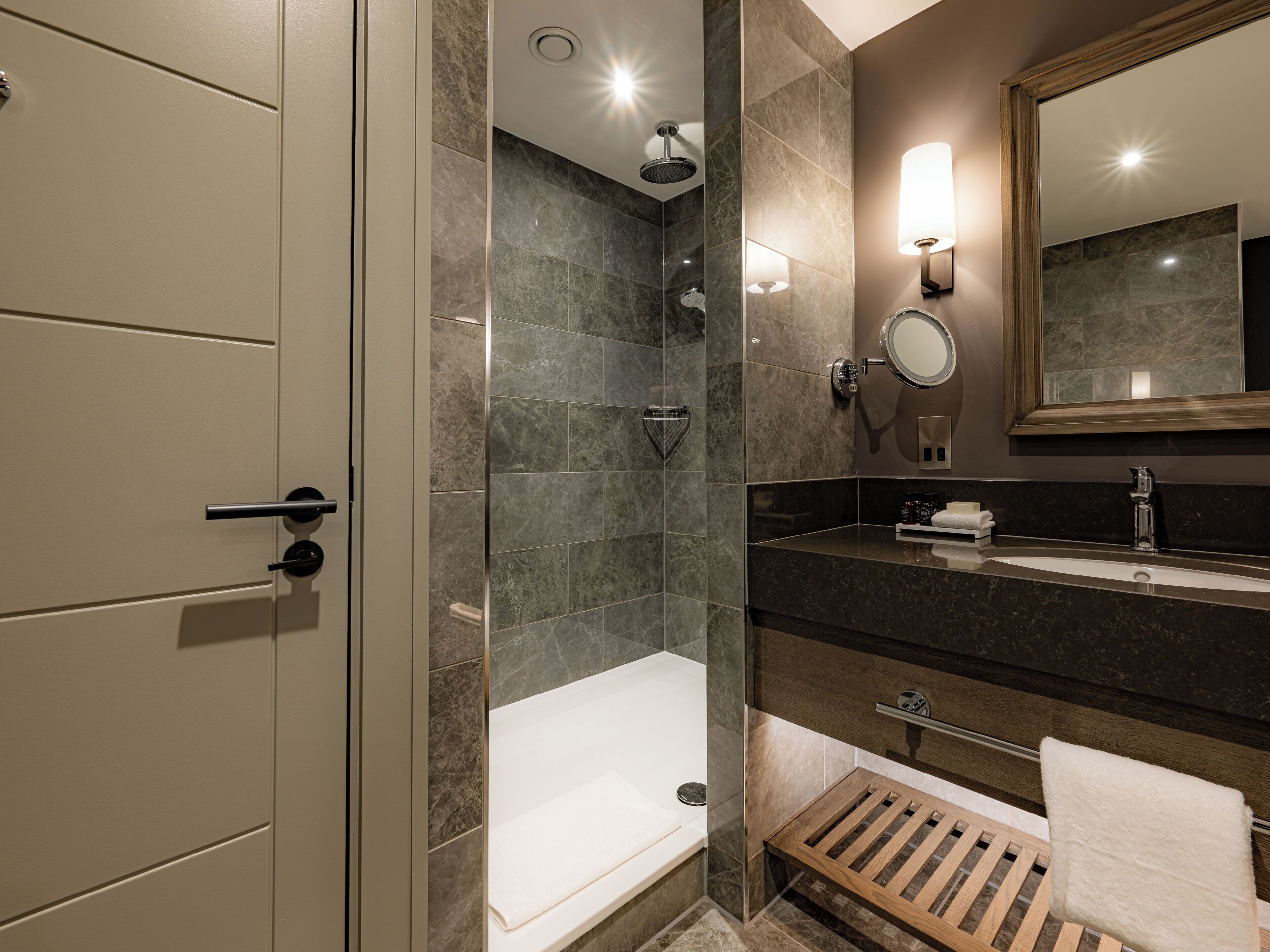 Un baño moderno con ducha, bañera, tocador con espejo y barra para toallas.