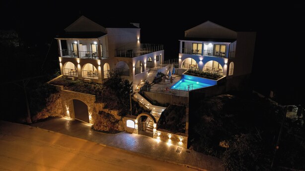 Una villa lussuosa con piscina, numerosi balconi e un ponte in pietra.