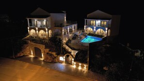 A luxurious villa with a swimming pool, multiple balconies, and a stone bridge. - Ostria Village (Sivota)