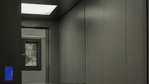 Interno di un ascensore moderno con corrimano metallico e porta con oblò.